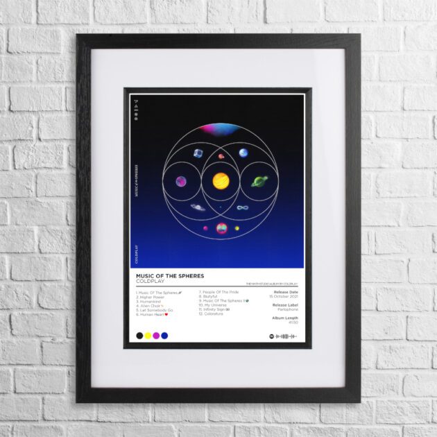 A4 custom design poster of Coldplay - Music of the Spheres in a black, dual-aspect frame on a white brick background