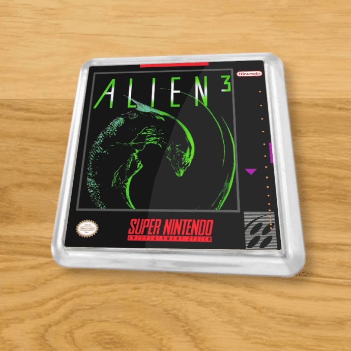 Plastic Alien 3 coaster on a wood table