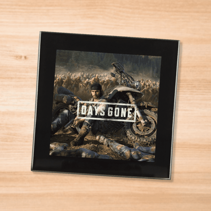 Black glass Days Gone coaster on a wood table