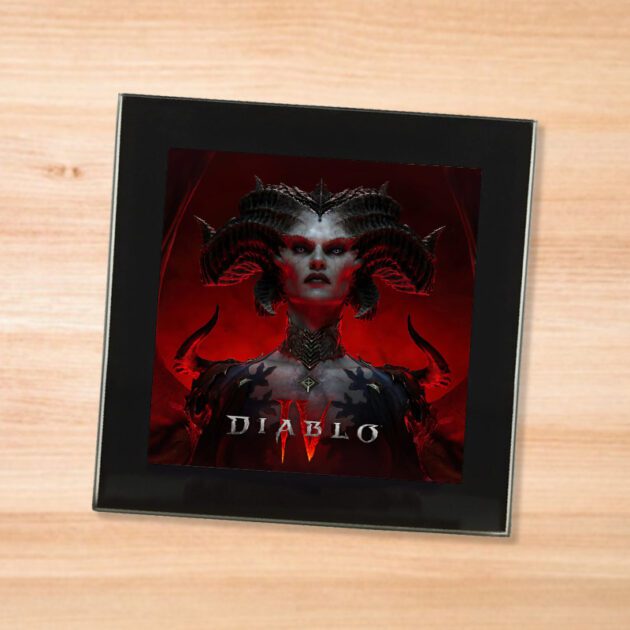 Black glass Diablo IV coaster on a wood table