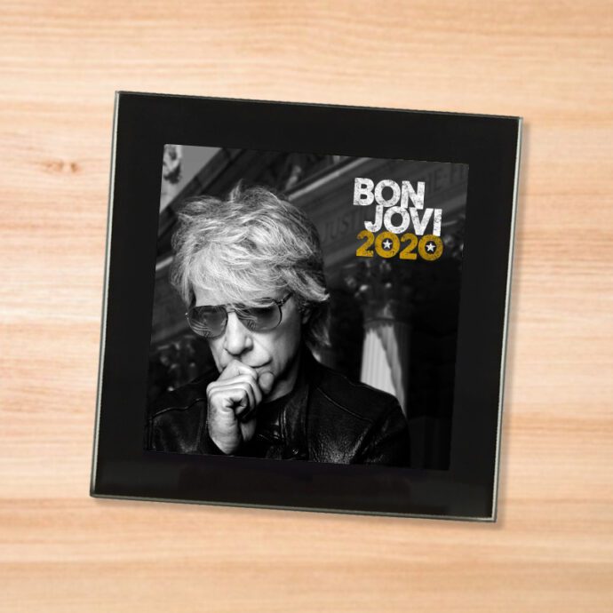 Black glass Bon Jovi - 2020 coaster on a wood table