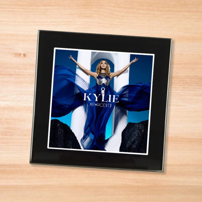 Black glass Kylie - Aphrodite coaster on a wood table