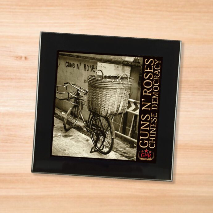 Black glass Guns N Roses - Chinese Democracy coaster on a wood table