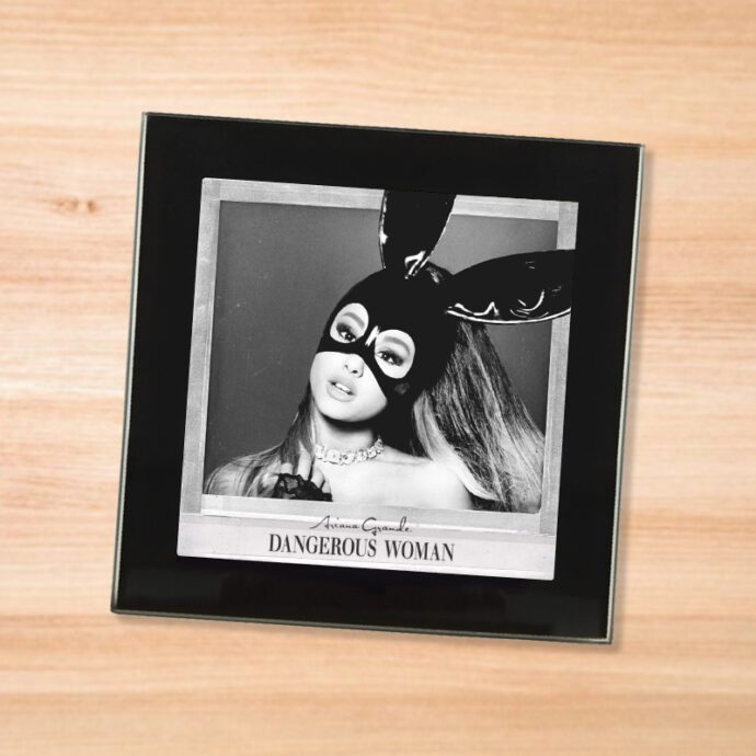Black glass Ariana Grande - Dangerous Woman coaster on a wood table