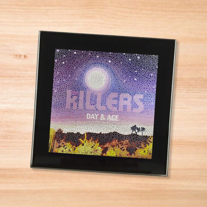 Black glass The Killers - Day & Age coaster on a wood table