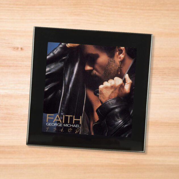 Black glass George Michael - Faith coaster on a wood table