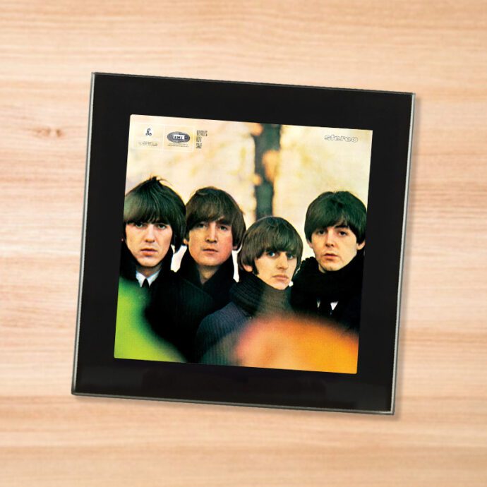 Black glass The Beatles - For Sale coaster on a wood table