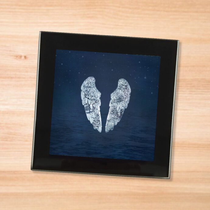 Black glass Coldplay - Ghost Stories coaster on a wood table