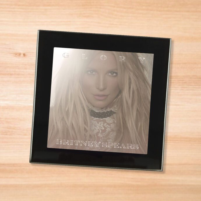 Black glass Britney Spears - Glory coaster on a wood table