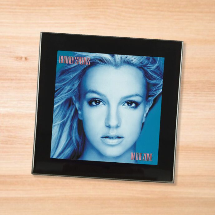 Black glass Britney Spears - In The Zone coaster on a wood table