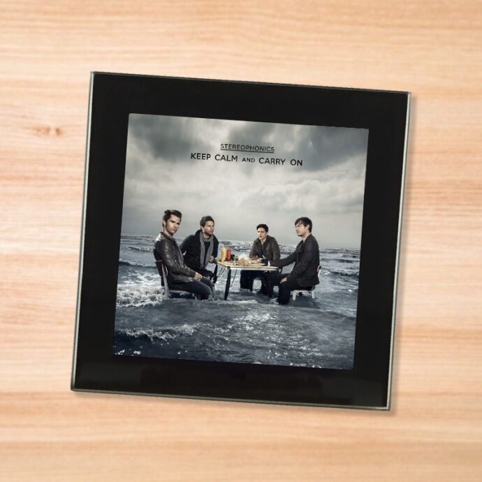 Black glass Stereophonics - Keep Calm and Carry On coaster on a wood table