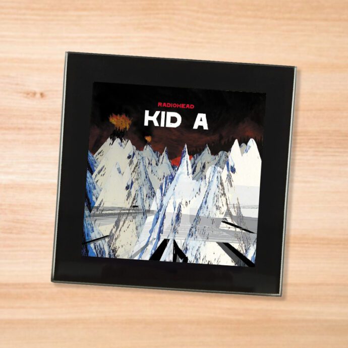 Black glass Radiohead - Kid A coaster on a wood table