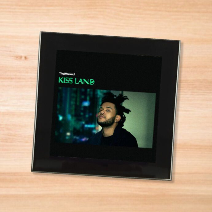Black glass The Weeknd - Kiss Land coaster on a wood table