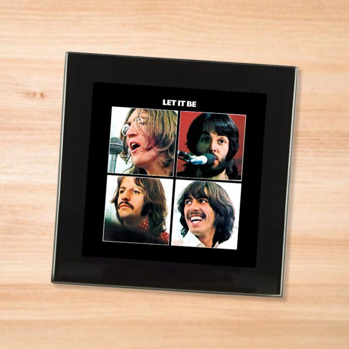 Black glass The Beatles - Let It Be coaster on a wood table