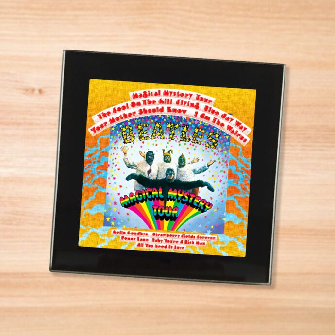 Black glass The Beatles - Magical Mystery Tour coaster on a wood table