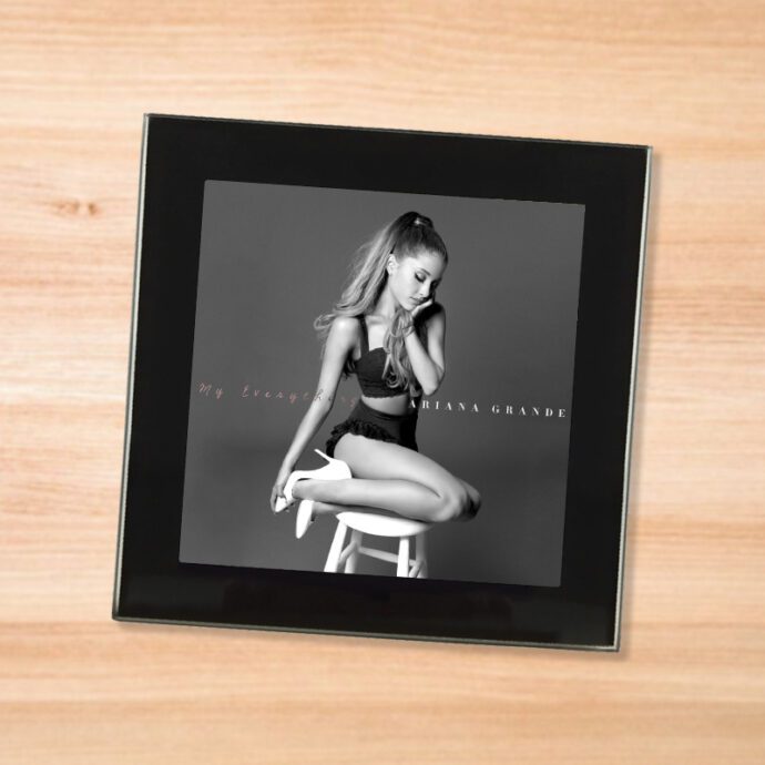 Black glass Ariana Grande - My Everything coaster on a wood table
