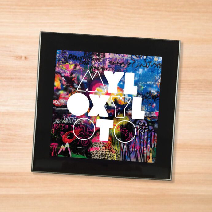 Black glass Coldplay - Mylo Xyloto coaster on a wood table