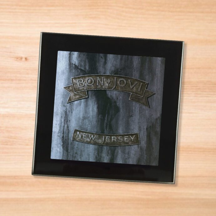 Black glass Bon Jovi - New Jersey coaster on a wood table