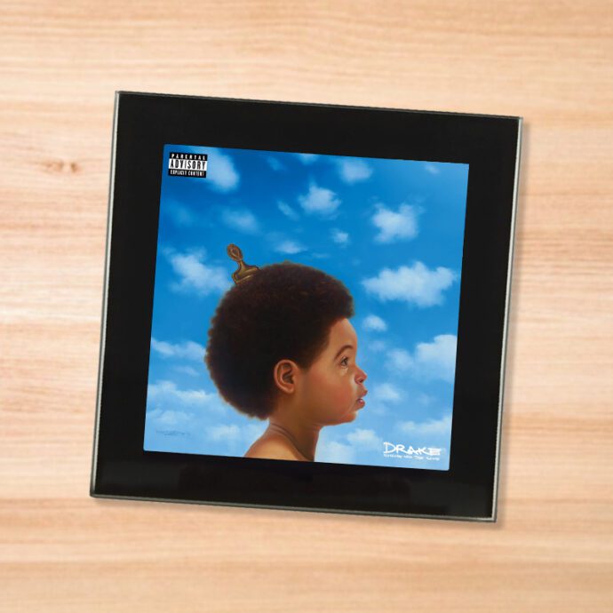 Black glass Drake - Nothing Was The Same coaster on a wood table