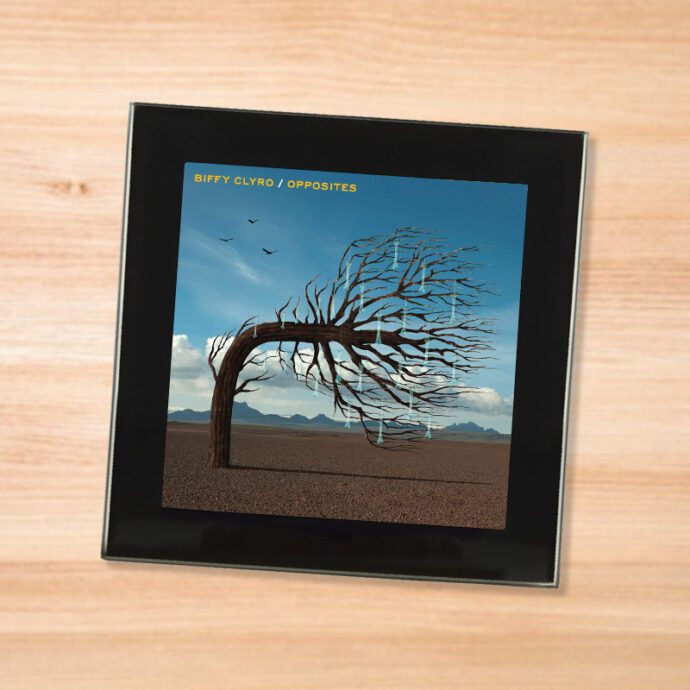 Black glass Biffy Clyro - Opposites coaster on a wood table