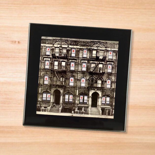 Black glass Led Zeppelin - Physical Graffiti coaster on a wood table
