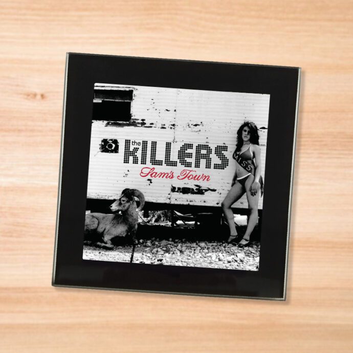 Black glass The Killers - Sam's Town coaster on a wood table