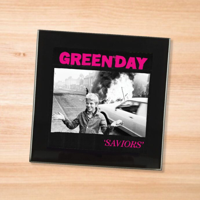 Black glass Green Day - Saviors coaster on a wood table
