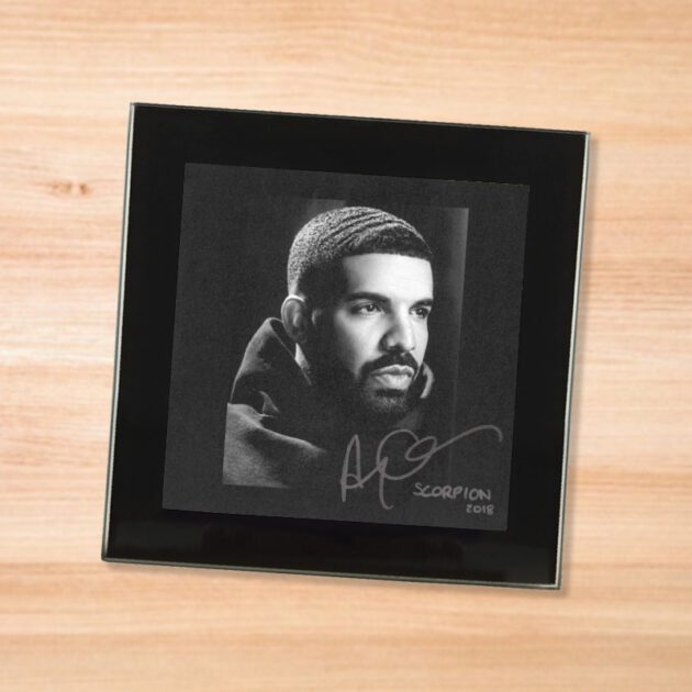 Black glass Drake - Scorpion coaster on a wood table