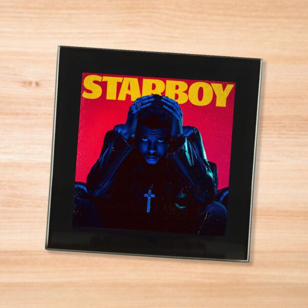 Black glass The Weeknd - Starboy coaster on a wood table