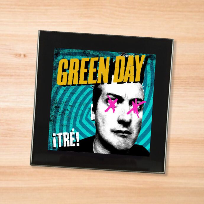 Black glass Green Day - Tre! coaster on a wood table