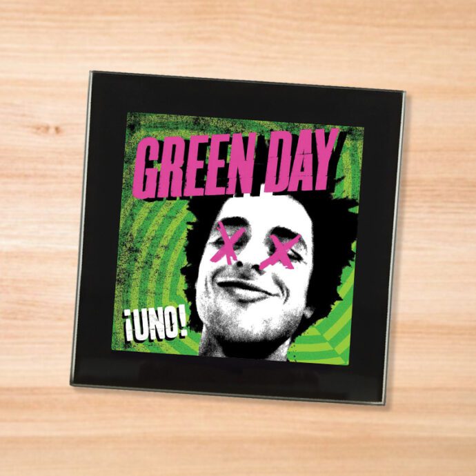 Black glass Green Day - Uno! coaster on a wood table