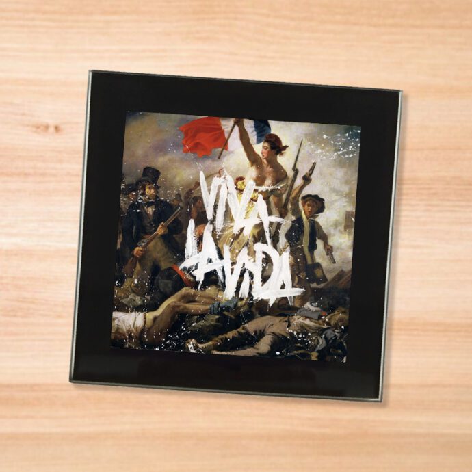 Black glass Coldplay - Viva la Vida coaster on a wood table