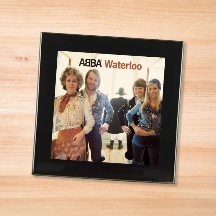 Black glass ABBA - Waterloo coaster on a wood table