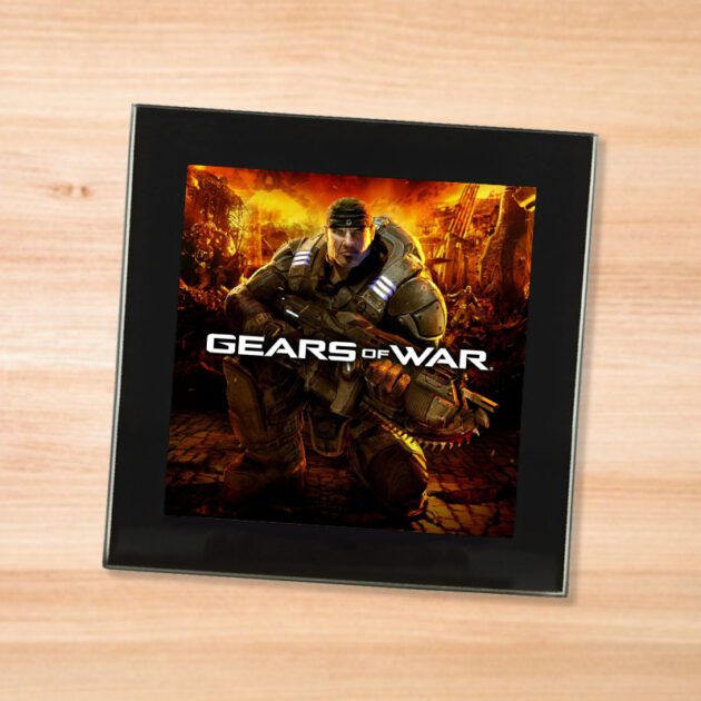 Black glass Gears of War coaster on a wood table