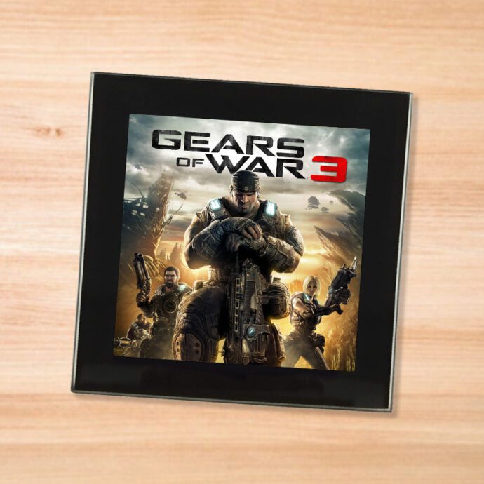 Black glass Gears of War 3 coaster on a wood table