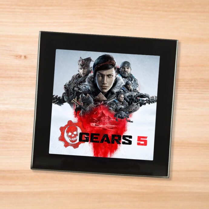 Black glass Gears of War 5 coaster on a wood table