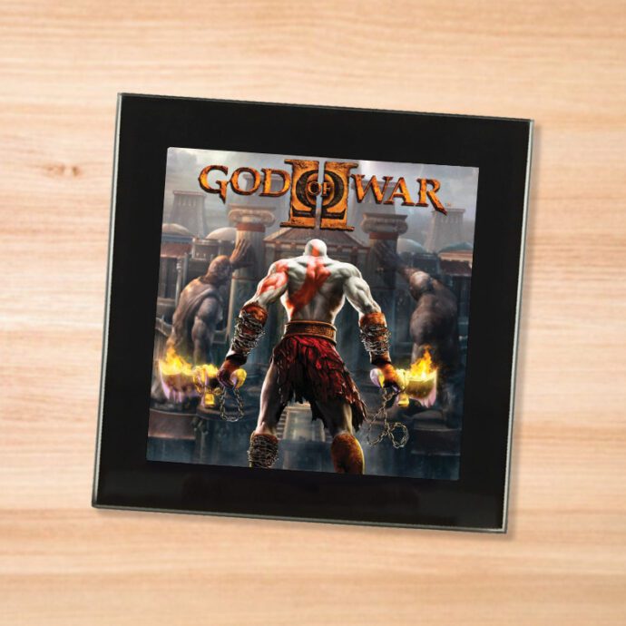 Black glass God of War 2 coaster on a wood table