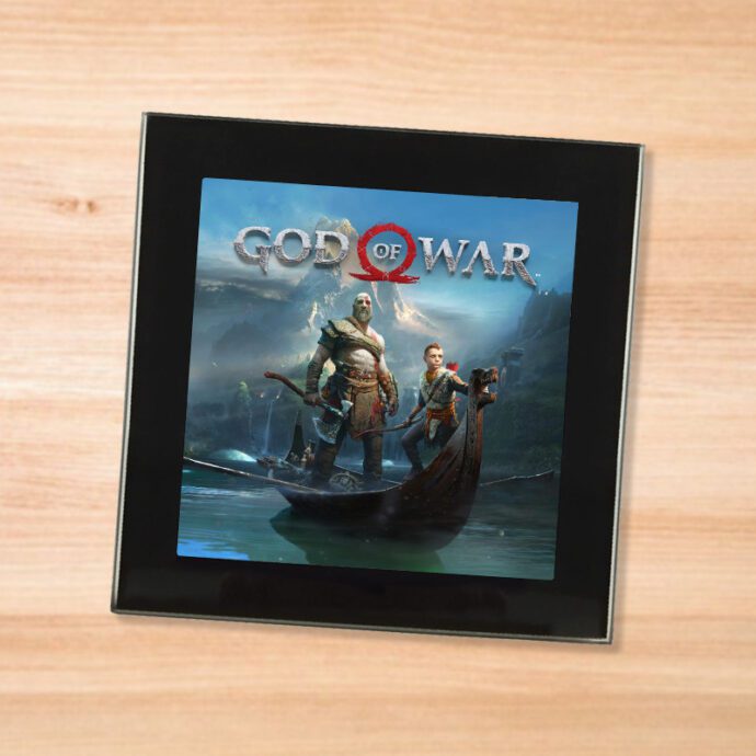 Black glass God of War coaster on a wood table