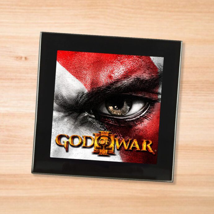 Black glass God of War 3 coaster on a wood table