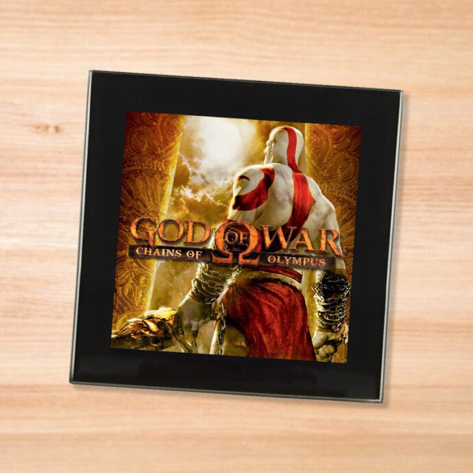 Black glass God of War Chains of Olympus coaster on a wood table