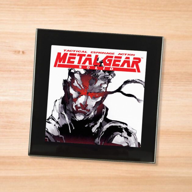 Black glass Metal Gear Solid coaster on a wood table