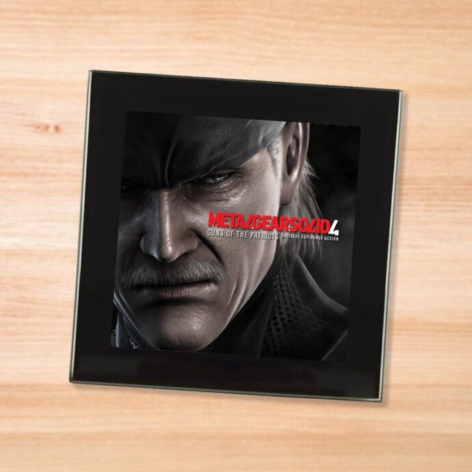 Black glass Metal Gear Solid 4 coaster on a wood table