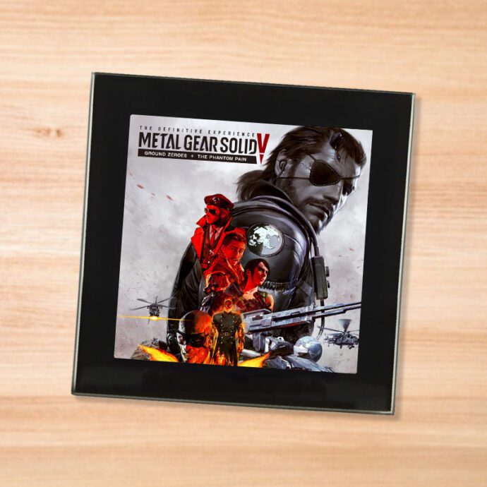 Black glass Metal Gear Solid 5 Definitive coaster on a wood table