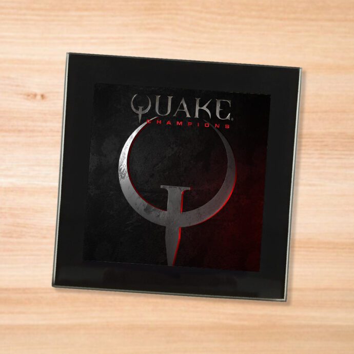 Black glass Quake Champions coaster on a wood table