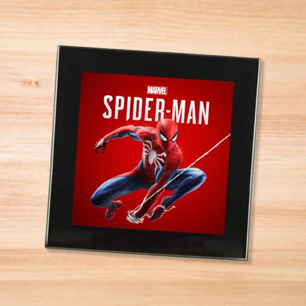 Black glass Spider-Man coaster on a wood table