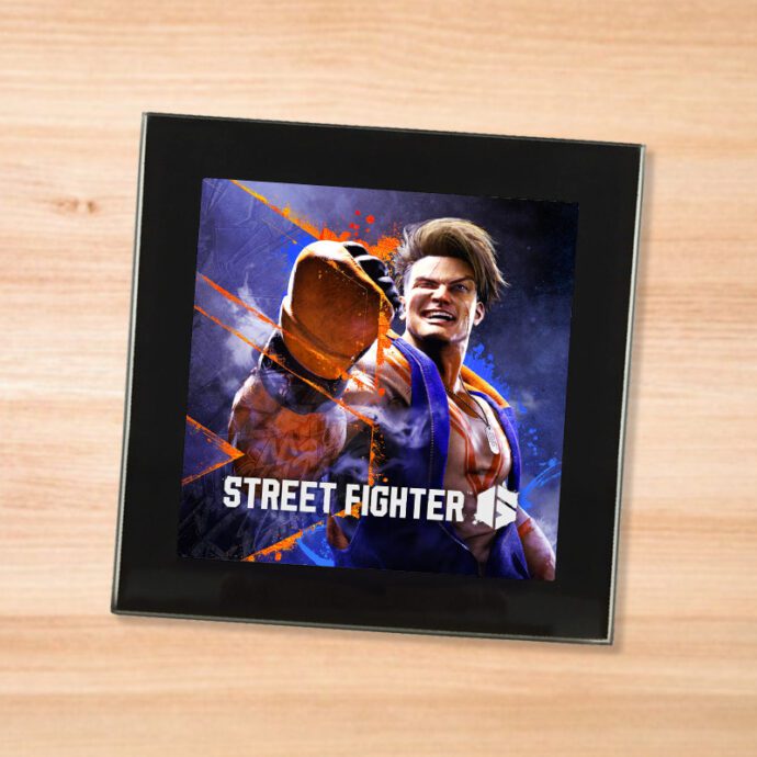 Black glass Street Fighter 6 coaster on a wood table