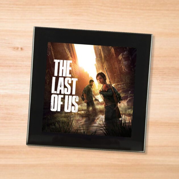 Black glass The Last Of Us coaster on a wood table