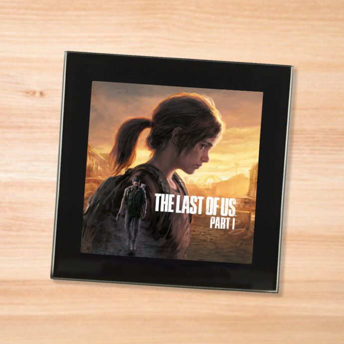 Black glass The Last Of Us Part 1 coaster on a wood table