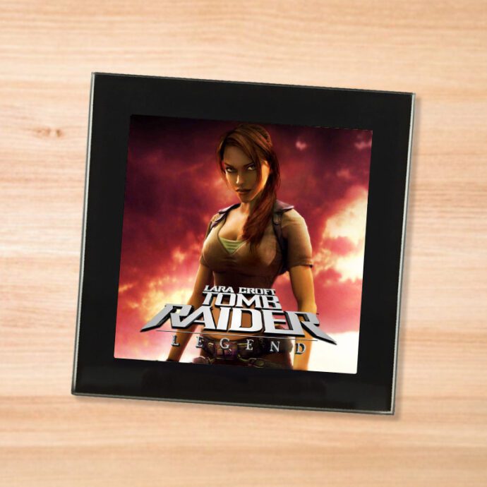 Black glass Tomb Raider Legend coaster on a wood table