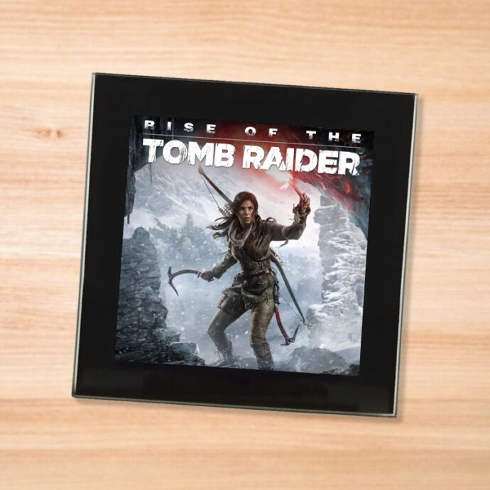 Black glass Rise of the Tomb Raider coaster on a wood table